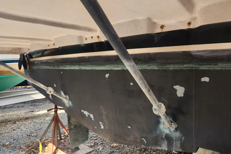 Slide: The Image of 1987 Luhrs 40 Convertible boat hull with visible wear and support stands. - 30