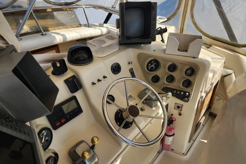 Slide: The Image of 1987 Luhrs 40 Convertible boat cockpit with steering wheel, gauges, and navigation equipment. - 31