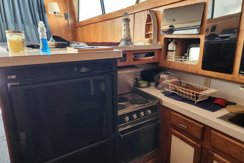 Slide: The Image of 1987 Luhrs 40 Convertible yacht kitchen with stove, oven, and wooden cabinetry. - 37