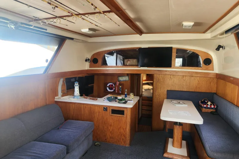 Slide: The Image of Interior of 1987 Luhrs 40 Convertible yacht with cozy seating and wooden accents. - 4