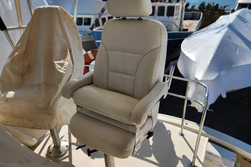 Slide: The Image of Captain's chair on 1987 Luhrs 40 Convertible boat deck, surrounded by covered equipment. - 40