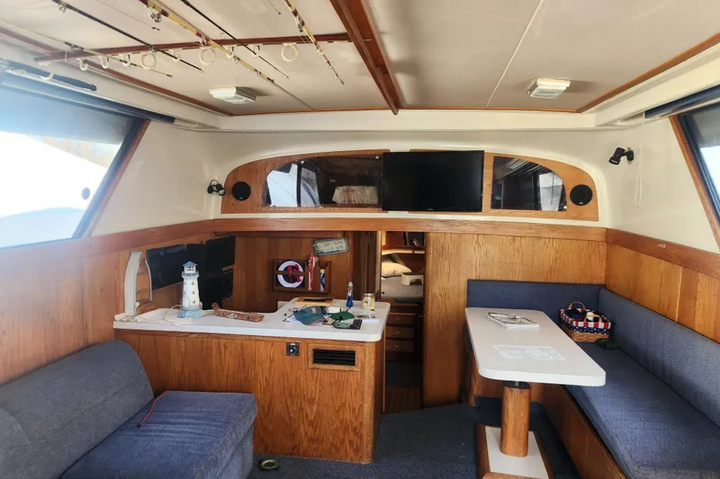 Slide: The Image of 1987 Luhrs 40 Convertible yacht interior with wood paneling, seating, and fishing rods. - 5