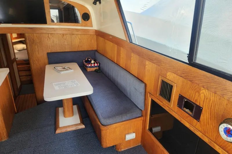 Slide: The Image of 1987 Luhrs 40 Convertible interior with wooden paneling and cozy seating area. - 6