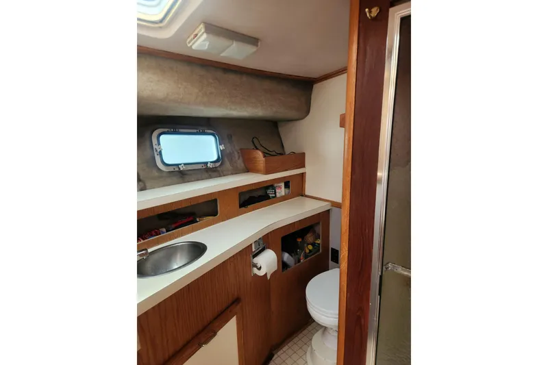 Slide: The Image of 1987 Luhrs 40 Convertible yacht bathroom with sink, toilet, and storage shelves. - 9