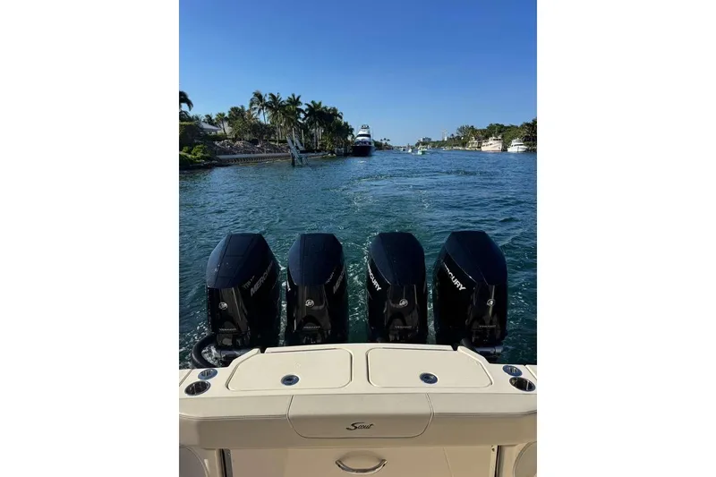 Slide: The Image of 2025 Scout 425 LXF boat with four Mercury engines on a scenic waterway. - 19