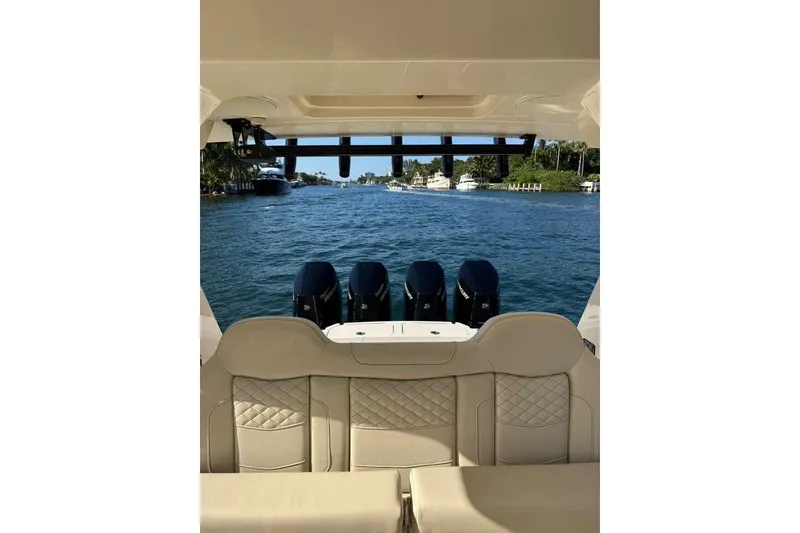 Slide: The Image of 2025 Scout 425 LXF boat with luxurious seating and powerful engines on a scenic waterway. - 20