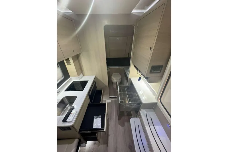 Slide: The Image of Modern interior of 2025 Scout 425 LXF boat featuring kitchen and bathroom amenities. - 23