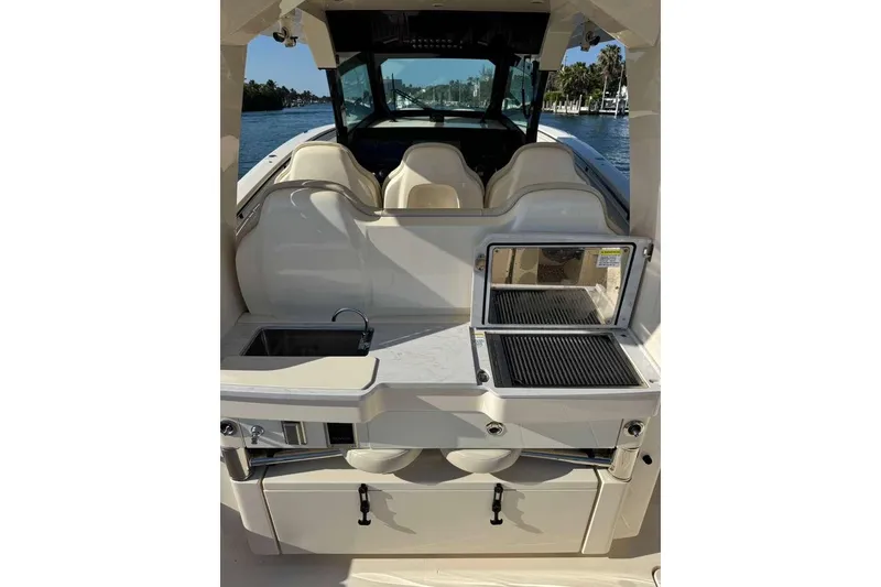 Slide: The Image of 2025 Scout 425 LXF boat interior with grill and sink, docked by the water. - 30
