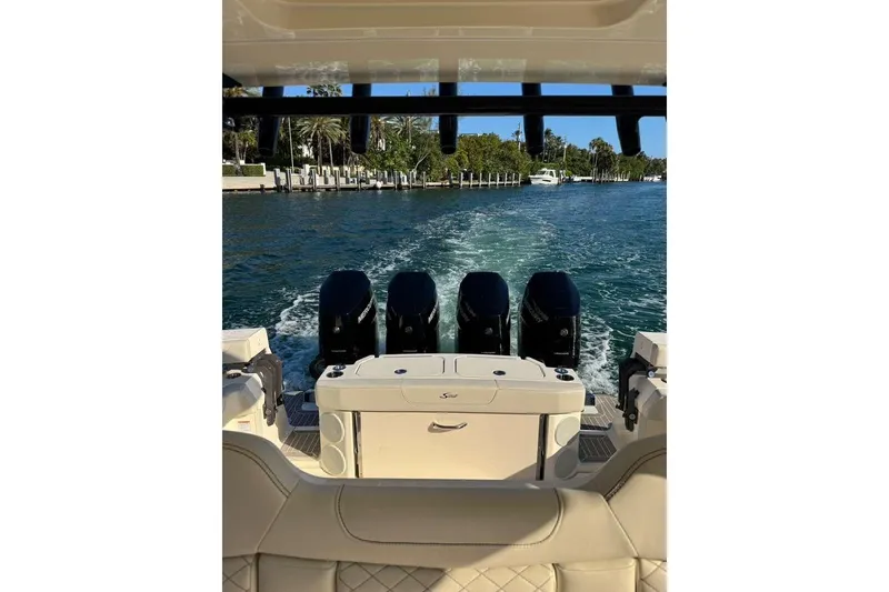 Slide: The Image of 2025 Scout 425 LXF boat cruising on a sunny waterway with four powerful engines. - 32