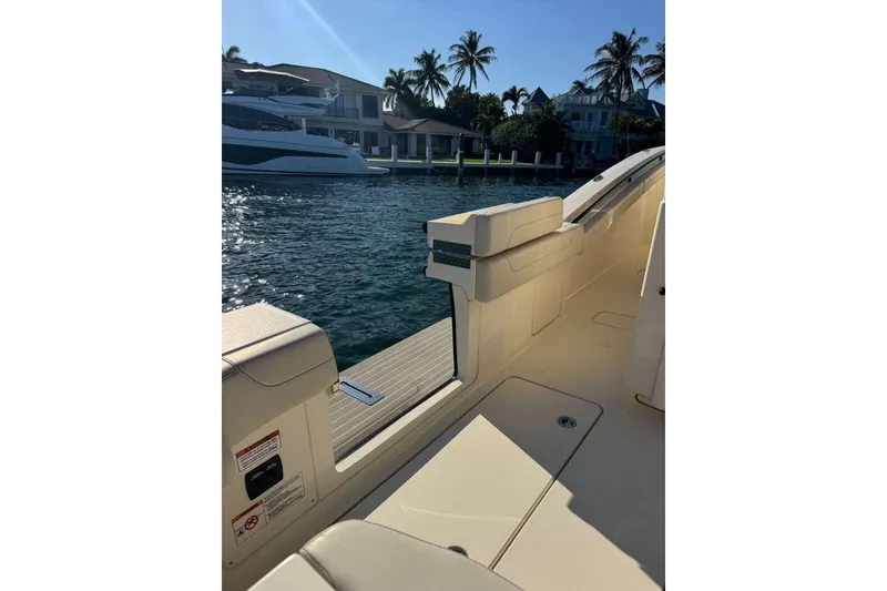 Slide: The Image of Luxurious 2025 Scout 425 LXF boat docked by waterfront homes, under clear blue sky. - 37