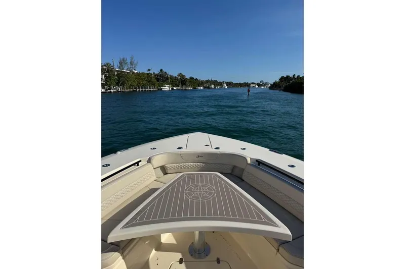 Slide: The Image of 2025 Scout 425 LXF boat cruising on a sunny day, featuring luxurious seating and table. - 38