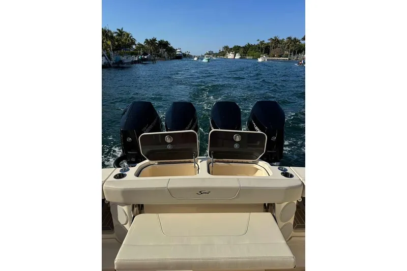 Slide: The Image of 2025 Scout 425 LXF boat with quad engines cruising on a scenic waterway. - 41
