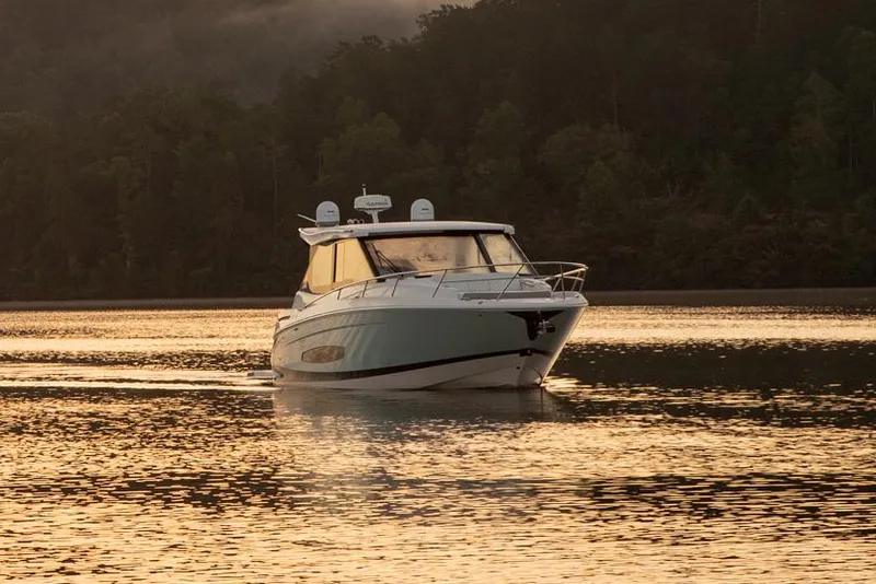 Slide: The Image of Manufacturer Provided Image: 2026 Regal 36 Grande Coupe cruising on a serene lake at sunset. - 2