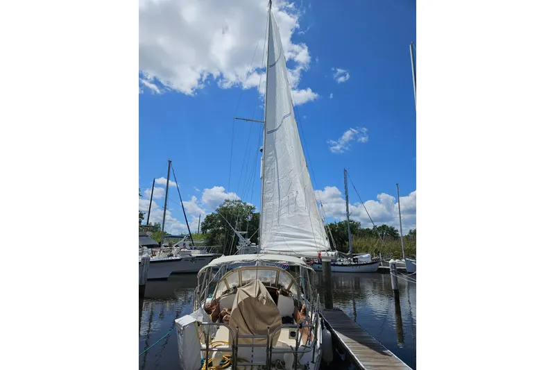 Slide: The Image of 1988 Cape Dory 38 sailboat docked under a clear blue sky. - 10