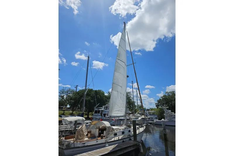 Slide: The Image of Sailboat Cape Dory 38, 1988 model, docked under a bright blue sky. - 11