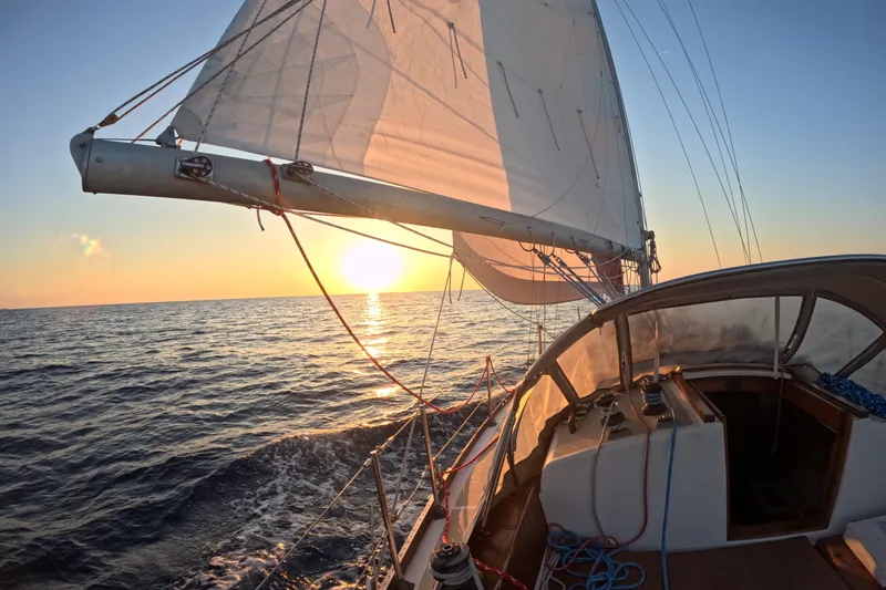 Slide: The Image of Sailing Cape Dory 36 yacht at sunset, 1988 model, on open ocean waters. - 13