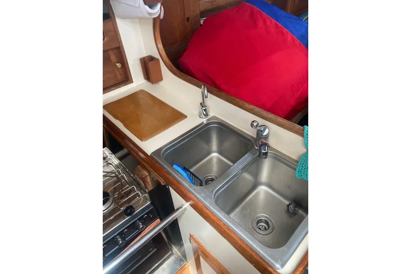 Slide: The Image of Galley sink area in 1988 Cape Dory 36 sailboat with dual basins and wooden accents. - 20