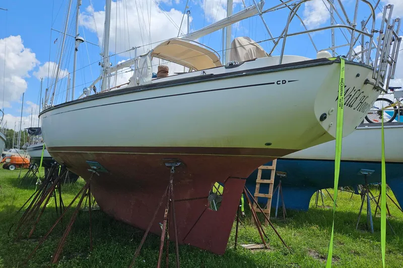 Slide: The Image of 1988 Cape Dory 36 sailboat on stands, under a clear blue sky. - 29