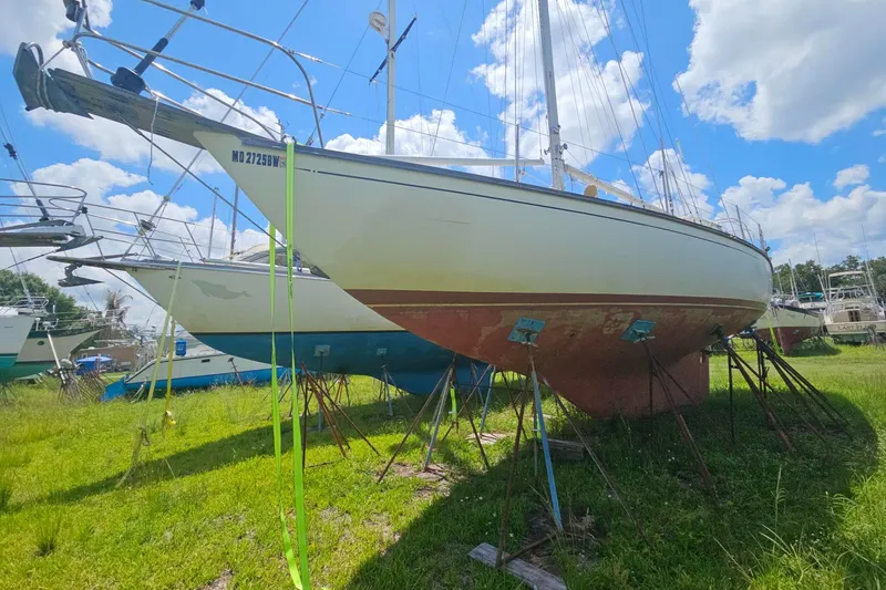 Slide: The Image of 1988 Cape Dory 36 sailboat on stands, under a bright blue sky with clouds. - 30