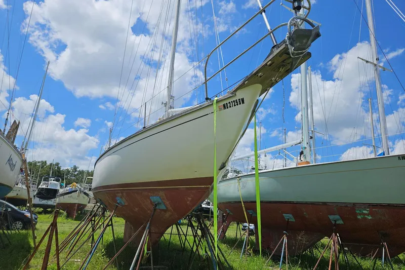 Slide: The Image of 1988 Cape Dory 36 sailboat on stands, under a bright blue sky with clouds. - 31