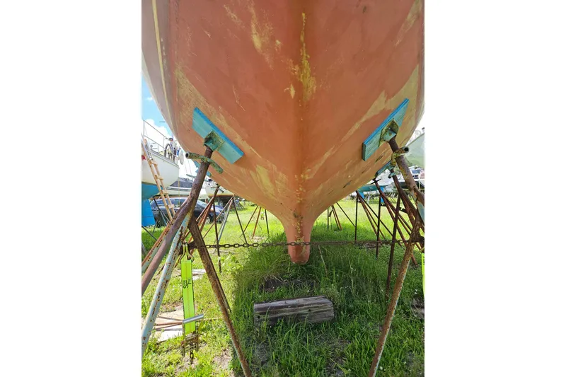 Slide: The Image of 1988 Cape Dory 36 sailboat hull on stands, showing weathered condition. - 33