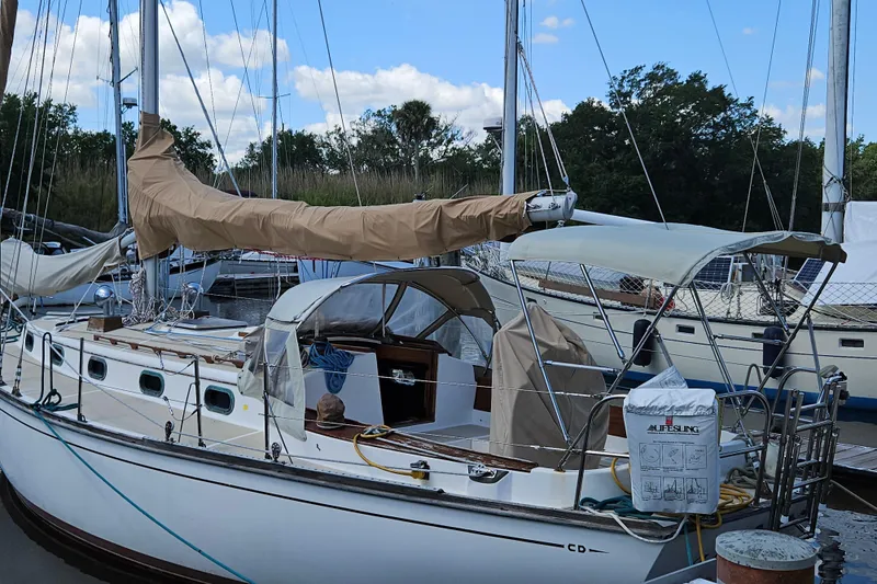 Slide: The Image of 1988 Cape Dory 38 sailboat docked, featuring covered sails and a spacious cockpit. - 4