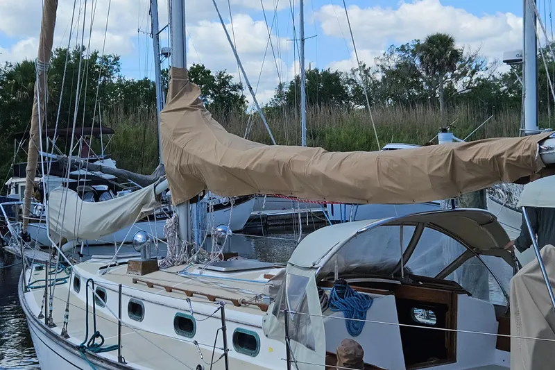 Slide: The Image of 1988 Cape Dory 38 sailboat docked, featuring covered sails and a classic design. - 5