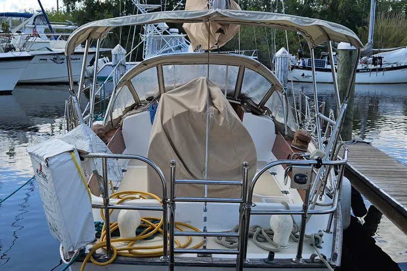 Slide: The Image of 1988 Cape Dory 38 sailboat docked, featuring covered cockpit and nautical equipment. - 7