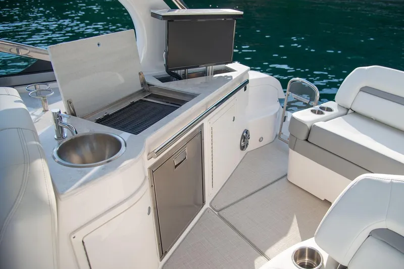 Slide: The Image of Manufacturer Provided Image: 2026 Regal 33 Express boat interior with kitchenette and seating, featuring a sink and grill. - 5
