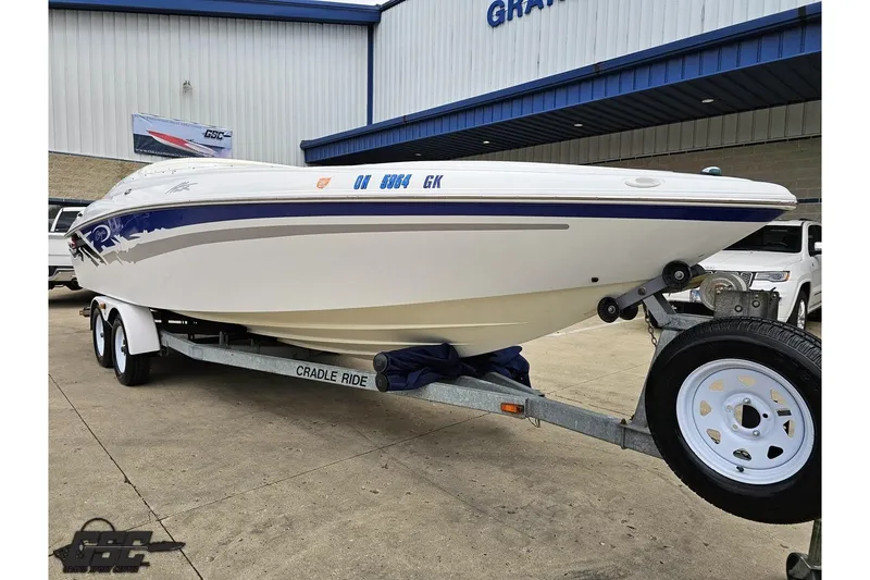 Slide: The Image of 2004 Baja H2X boat on trailer outside dealership, showcasing sleek design and vibrant colors. - 13