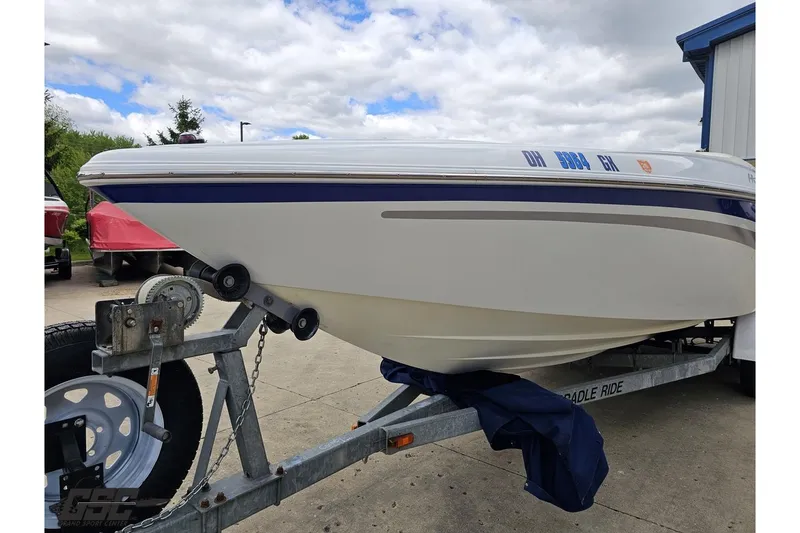 Slide: The Image of 2004 Baja H2X boat on trailer, parked outdoors under cloudy sky. - 16