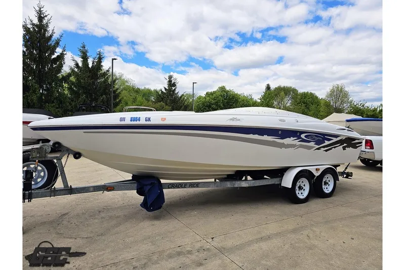 Slide: The Image of 2004 Baja H2X speedboat on trailer, parked outdoors under a partly cloudy sky. - 18