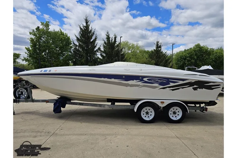 Slide: The Image of 2004 Baja H2X speedboat on trailer, parked outdoors under a cloudy sky. - 21