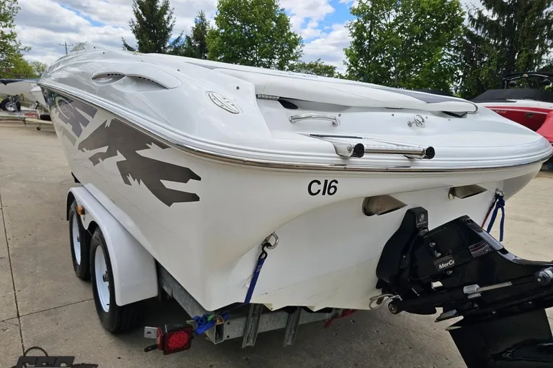 Slide: The Image of 2004 Baja H2X boat on trailer, white with black graphics, parked outdoors. - 29