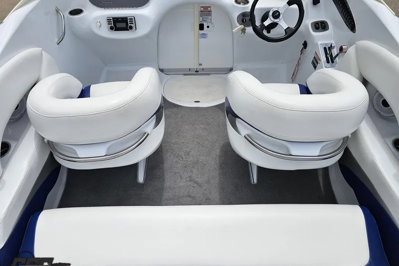Slide: The Image of Interior of a 2004 Baja H2X boat with white seating and modern dashboard. - 47