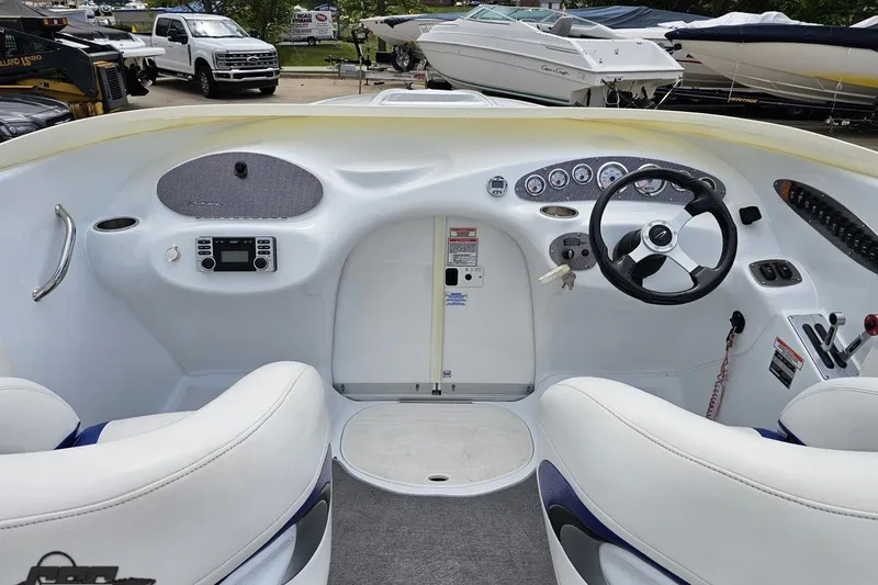 Slide: The Image of Interior view of a 2004 Baja H2X boat cockpit with steering wheel and controls. - 48