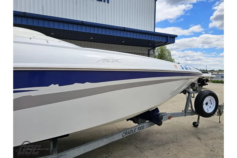 Slide: The Image of 2004 Baja H2X boat on trailer, parked outdoors under a blue sky. - 5