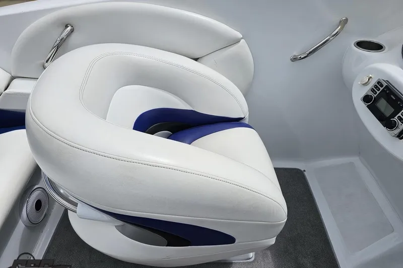 Slide: The Image of 2004 Baja H2X boat interior with white and blue seating, stereo system, and cup holder. - 54