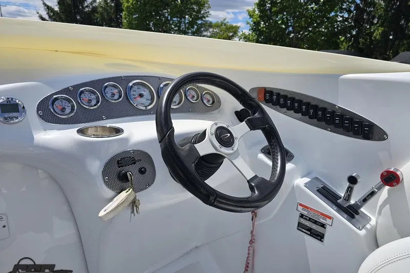 Slide: The Image of 2004 Baja H2X boat dashboard with steering wheel, gauges, and control switches. - 57