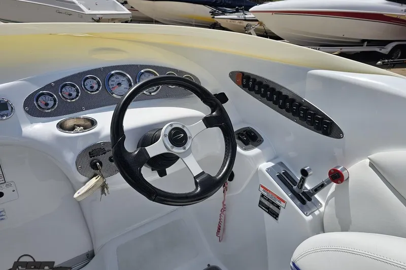 Slide: The Image of 2004 Baja H2X boat dashboard with steering wheel, gauges, and controls. - 58