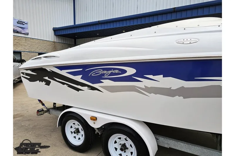 Slide: The Image of 2004 Baja H2X boat with blue and gray graphics on a trailer. - 6