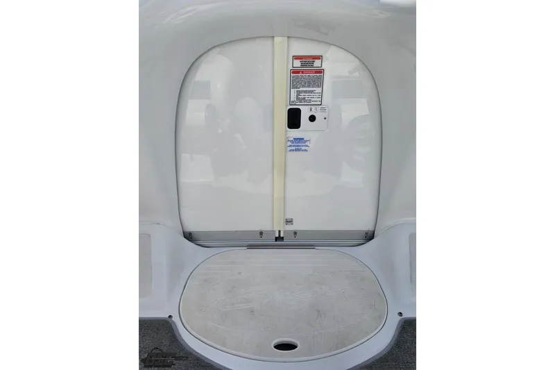 Slide: The Image of 2004 Baja H2X boat interior with safety labels and storage compartment. - 64