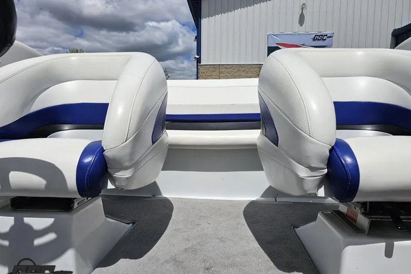 Slide: The Image of 2004 Baja H2X boat interior with white and blue seating under cloudy sky. - 76