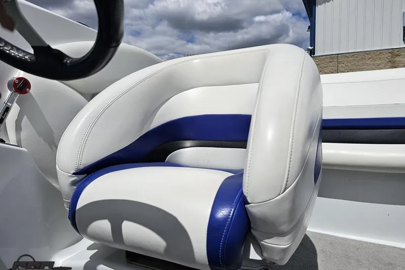 Slide: The Image of 2004 Baja H2X boat interior with white and blue seating under cloudy sky. - 78