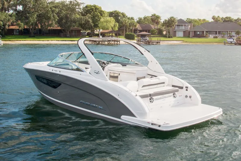 Slide: The Image of Manufacturer Provided Image: 2026 Regal 3300 boat on a serene lake with lush greenery and waterfront homes. - 5