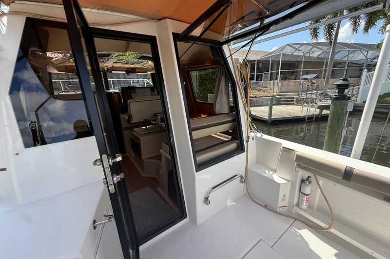 Slide: The Image of 2019 Ranger Tugs R-27 boat interior view with open door, dockside setting. - 12