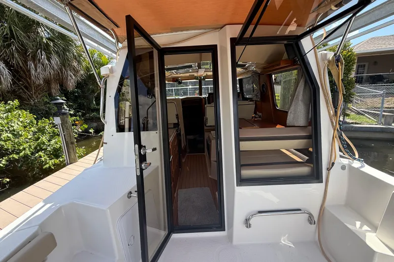 Slide: The Image of 2019 Ranger Tugs R-27 boat interior with open door, dockside view. - 13