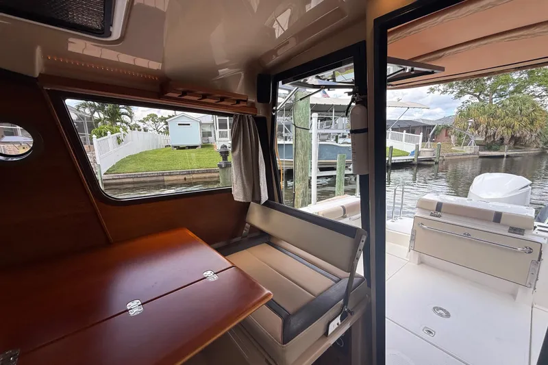 Slide: The Image of Interior view of 2019 Ranger Tugs R-27 boat, featuring dining area and open deck access. - 17
