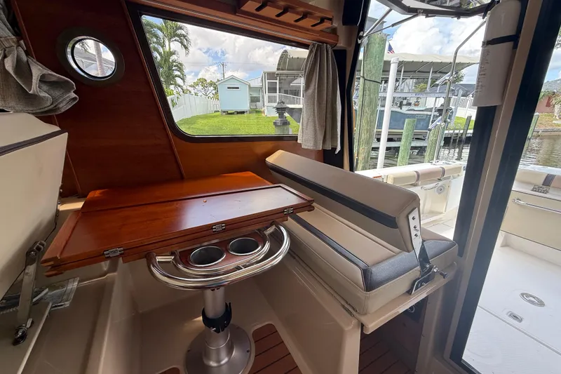 Slide: The Image of Interior of 2019 Ranger Tugs R-27 boat with wooden table and seating. - 18