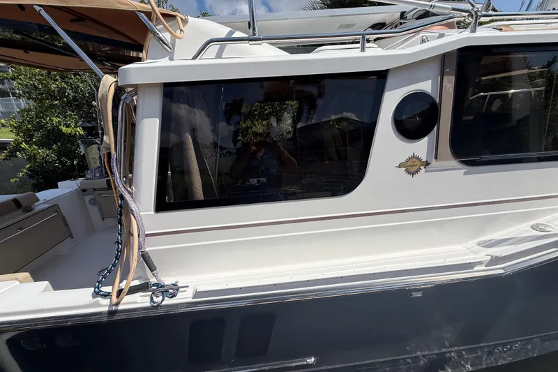 Slide: The Image of 2019 Ranger Tugs R-27 boat side view with windows and deck details. - 2